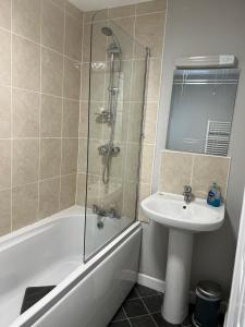 a bathroom with a shower and a sink and a tub at Impeccable 1-Bed Apartment in Ulverston in Ulverston