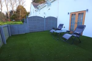 a patio with two chairs and a table and a fence at The Lodge - Studio Apartment's in Castel