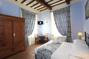 1 dormitorio con 1 cama y 1 mesa con sillas en Palazzo Mari, en San Gimignano