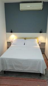a large white bed in a bedroom with a blue wall at Lapa Bed & Breakfast in Rio de Janeiro