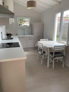 a white kitchen with a table and chairs in it at Maison traditionnelle de pêcheur in Île dʼAix