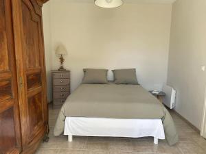 a bedroom with a bed and a dresser with a lamp at Maison traditionnelle de pêcheur in Île dʼAix
