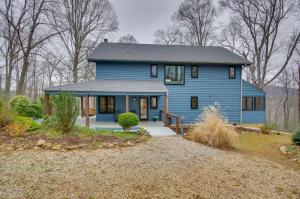 a blue house with a driveway in front of it at Modern Nellysford Getaway on 40 Private Acres! in Wintergreen
