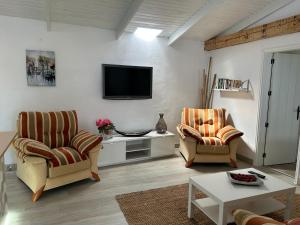 a living room with two chairs and a tv at Casa La Oliva in Garachico