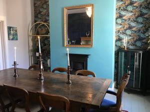 een eetkamer met een houten tafel met kaarsen erop bij Carlton House - Spacious 4 Bed Victorian townhouse in Harrogate