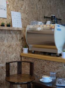 uma máquina de café sentada numa prateleira ao lado de uma mesa em @Home Hostel Wua Lai em Chiang Mai