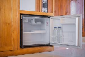 - un réfrigérateur ouvert avec 2 bouteilles d'eau dans l'établissement The Oni Bisma, à Ubud