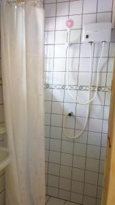 een douche met een wit douchegordijn in de badkamer bij Dunkirk Residence in Willemstad