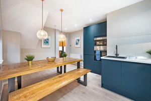 een keuken met een houten tafel en blauwe kasten bij Host & Stay - The Coachouse at Pilgrim St in Liverpool