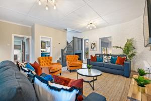 a living room with blue couches and orange chairs at Host & Stay - The Coachouse at Pilgrim St in Liverpool