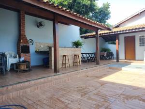 an outdoor patio with a fireplace in a house at RECANTO DAS ARARAS in Olímpia