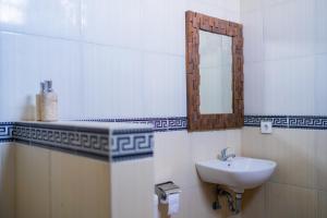 La salle de bains est pourvue d'un lavabo et d'un miroir. dans l'établissement The Oni Bisma, à Ubud