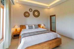 - une chambre avec un lit et deux miroirs sur le mur dans l'établissement The Oni Bisma, à Ubud
