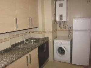 una pequeña cocina con fregadero y lavadora en Apartamento ideal en Guadix