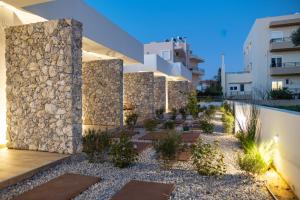 a facade of a building with a stone wall at Pebble Garden Orchid in Kos Town