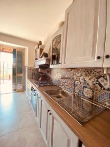 a kitchen with white cabinets and a sink at La Tana in Serricciolo