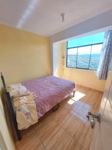 ein Schlafzimmer mit einem Bett und einem großen Fenster in der Unterkunft Disha's Home Casa Hospedaje in Ayacucho