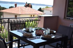 a table with plates of food on a balcony at Apartment Angela in Portorož