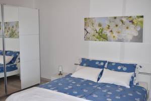 a bedroom with a bed with blue and white pillows at Apartment Angela in Portorož