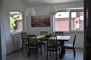 a dining room with a table and chairs and windows at Apartment Angela in Portorož +16 photos