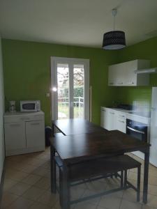 een keuken met een houten tafel in een kamer bij MAISON A 10MIN DU ZOO DE BEAUVAL in Noyers-sur-Cher