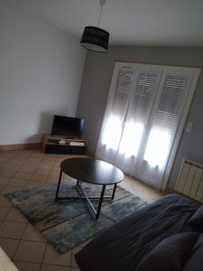 een woonkamer met een tafel en een bank bij MAISON A 10MIN DU ZOO DE BEAUVAL in Noyers-sur-Cher