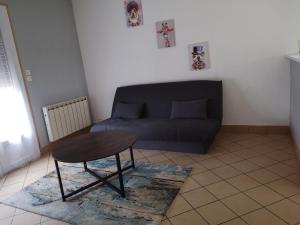 een woonkamer met een bank en een tafel bij MAISON A 10MIN DU ZOO DE BEAUVAL in Noyers-sur-Cher