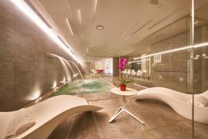 - une salle de bains avec une piscine au milieu de la chambre dans l'établissement iH Hotels Courmayeur Mont Blanc, à Courmayeur