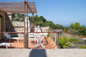 einen Balkon eines Hauses mit einem Tisch und Stühlen in der Unterkunft Allegroitalia Elba Golf in Portoferraio