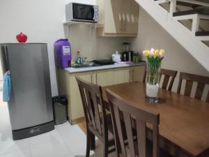 a kitchen with a wooden table and a refrigerator at Monteluce Staycation in Silang