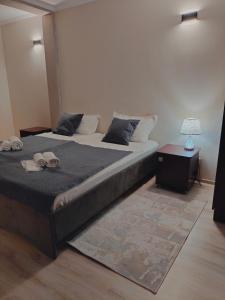 a bedroom with a large bed with two shoes on it at Phorto Bella in Ustʼ-Kamenogorsk