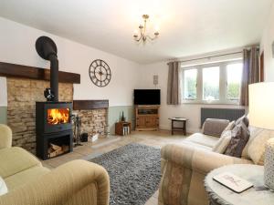 a living room with a couch and a fireplace at Honeystone Cottage in Moreton in Marsh