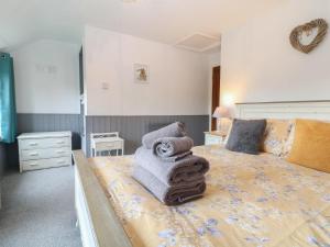 a bedroom with a bed with towels on it at Honeystone Cottage in Moreton in Marsh