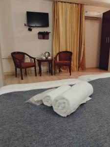 a hotel room with a bed with white towels on it at Phorto Bella in Ustʼ-Kamenogorsk