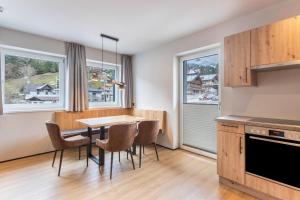 a kitchen with a table and chairs and windows at Luisalle Top 1 in Auffach