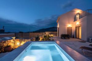 a swimming pool on the roof of a house at night at Pink Sand Villas in Agios Padeleimon