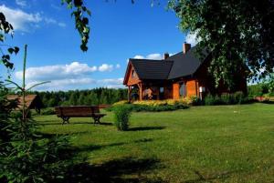 Redułty的住宿－Uroczy drewniany dom w ciszy i spokoju，坐在房子前面的长凳