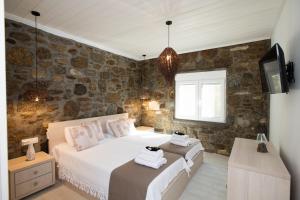 a bedroom with a bed and a tv in it at TIFFANYS VILLAS in Mikonos