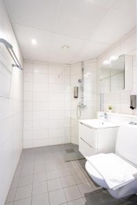 a white bathroom with a toilet and a sink at Hotell Hjalmar in Örebro