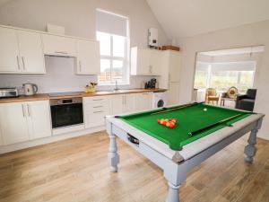 eine Küche mit einem Billardtisch in einem Zimmer in der Unterkunft The Poets Cottage in Ballymena