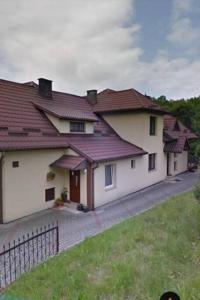 uma casa grande com telhados vermelhos e um quintal em Urokliwy dom w Nowym Sączu em Nowy Sącz