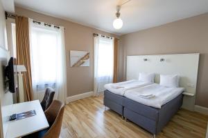 a bedroom with a bed and a table and chairs at Hotell Hjalmar in Örebro