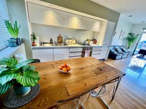 a kitchen with a wooden table with a bowl of fruit on it at Zen life with Urban Views - E8 Chic in London