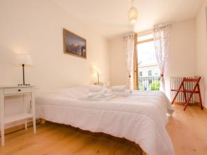 białe łóżko w pokoju z oknem w obiekcie Appartement central à Chamonix proche pistes avec balcon et WiFi - FR-1-343-194 w Chamonix-Mont-Blanc