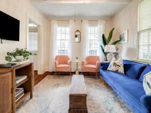 a living room with a blue couch and two chairs at Waldburg Cottage in Savannah