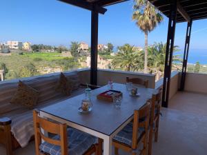 a table and chairs on a balcony with a view of the ocean at The Villa Gems in Roussospítion