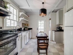 a kitchen with white cabinets and a table in it at Waldburg Cottage in Savannah