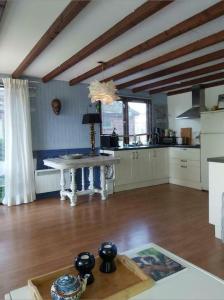 ein Wohnzimmer mit einem Tisch und einer Küche in der Unterkunft Hineni in Oostvoorne + 13 Fotos