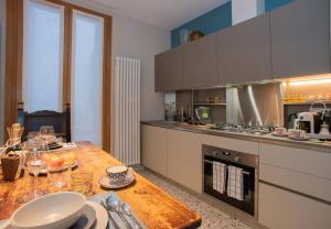 una cucina con tavolo in legno e bicchieri da vino di Casa del Carro 1 Grand Master Apartment a Venezia