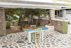 un tavolo e due sedie seduti su un patio di Thalassitra Village Hotel ad Adámas
